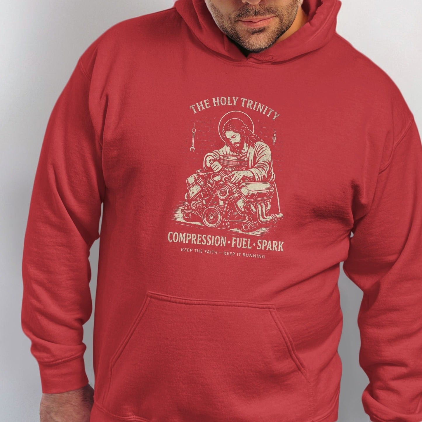 Red hoodie featuring illustration of Jesus working on an engine with text.