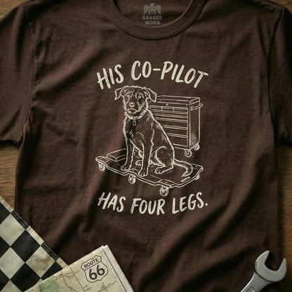 Brown t-shirt with a sketch of a dog on a toolbox and the text "HIS CO-PILOT HAS FOUR LEGS."