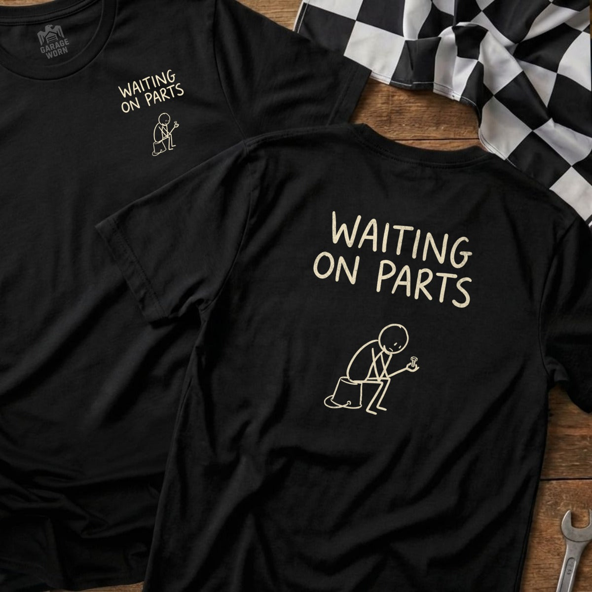Black t-shirt with "Waiting on Parts" text and stick figure drawing.
