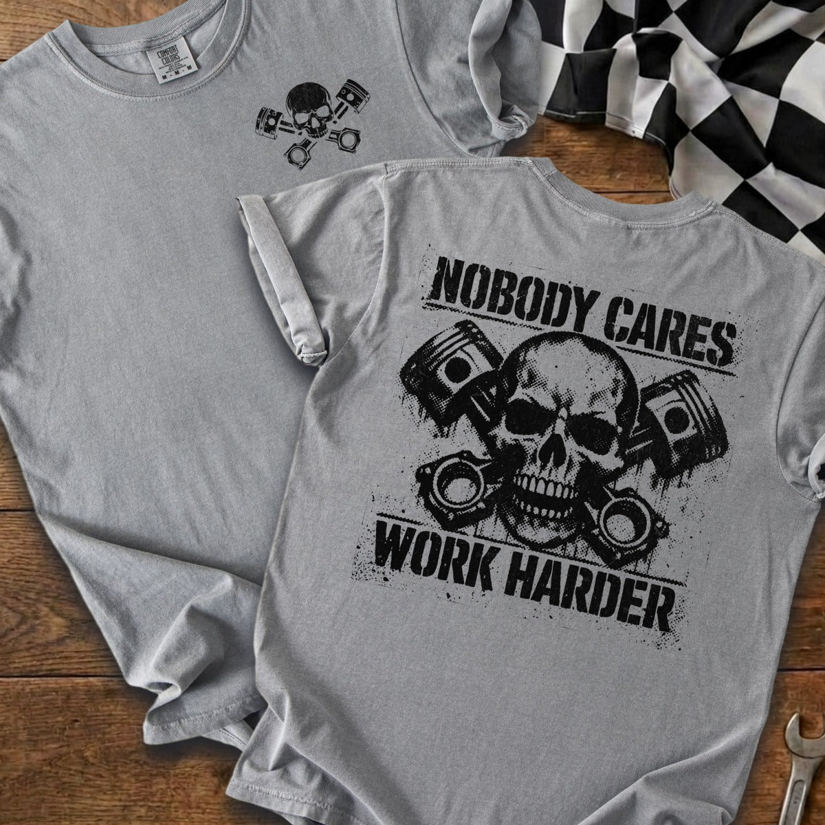 Gray t-shirt with skull and pistons graphic; "Nobody Cares Work Harder" text.
