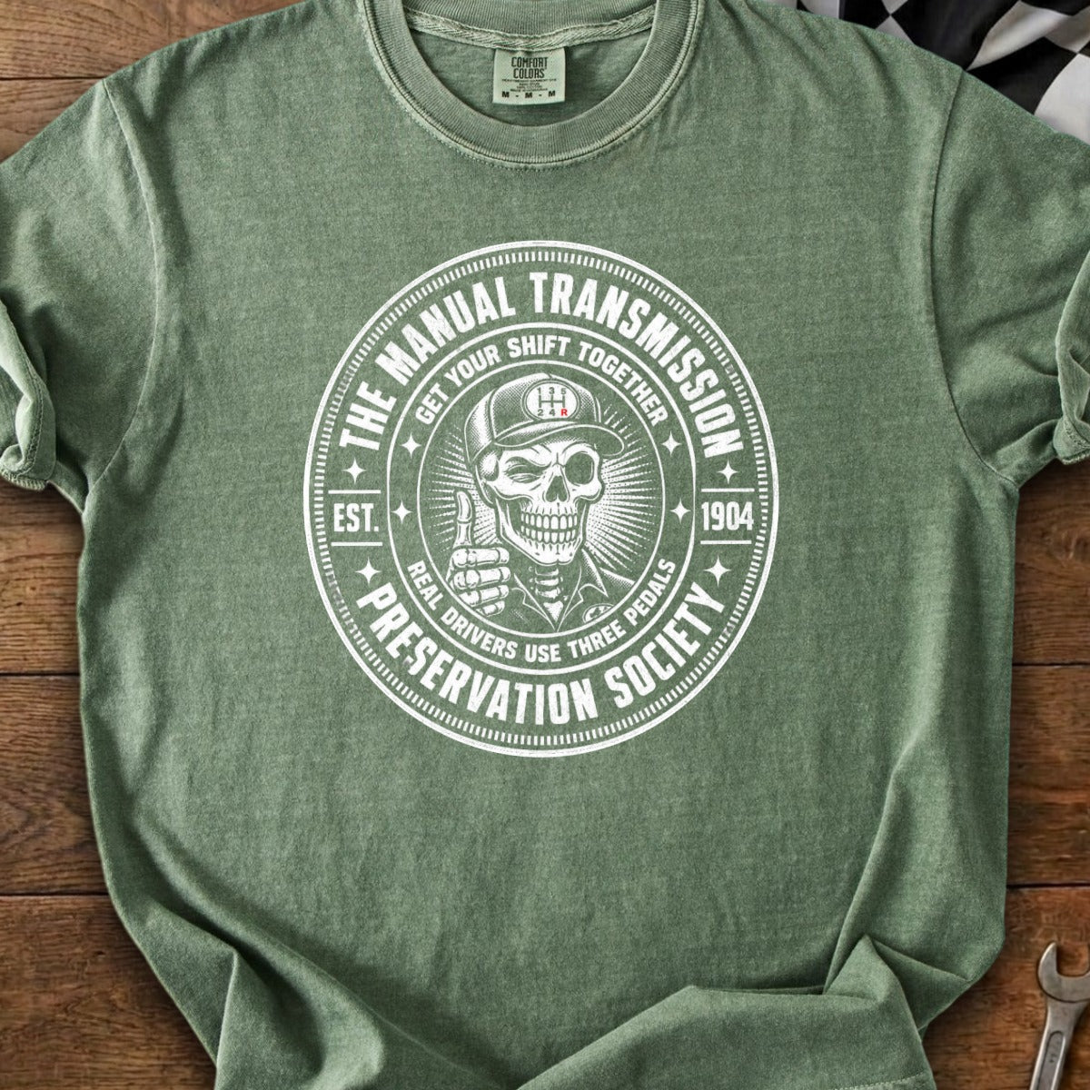 Green t-shirt with circle graphic: Manual Transmission Preservation Society, skull.