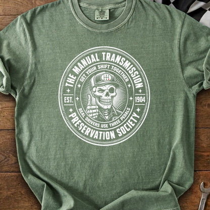 Green t-shirt with circle graphic: Manual Transmission Preservation Society, skull.