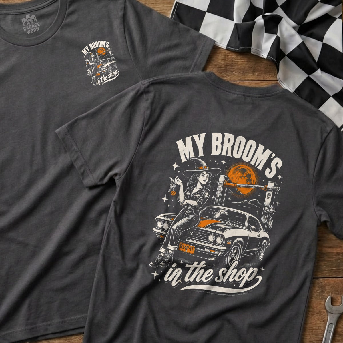 Dark grey t-shirt with witch and car graphic that reads "My Broom's In the Shop".