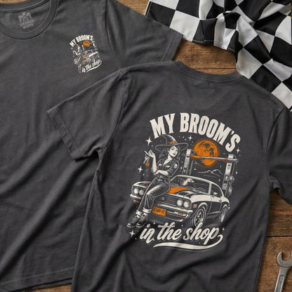 Dark grey t-shirt with witch and car graphic that reads "My Broom's In the Shop".