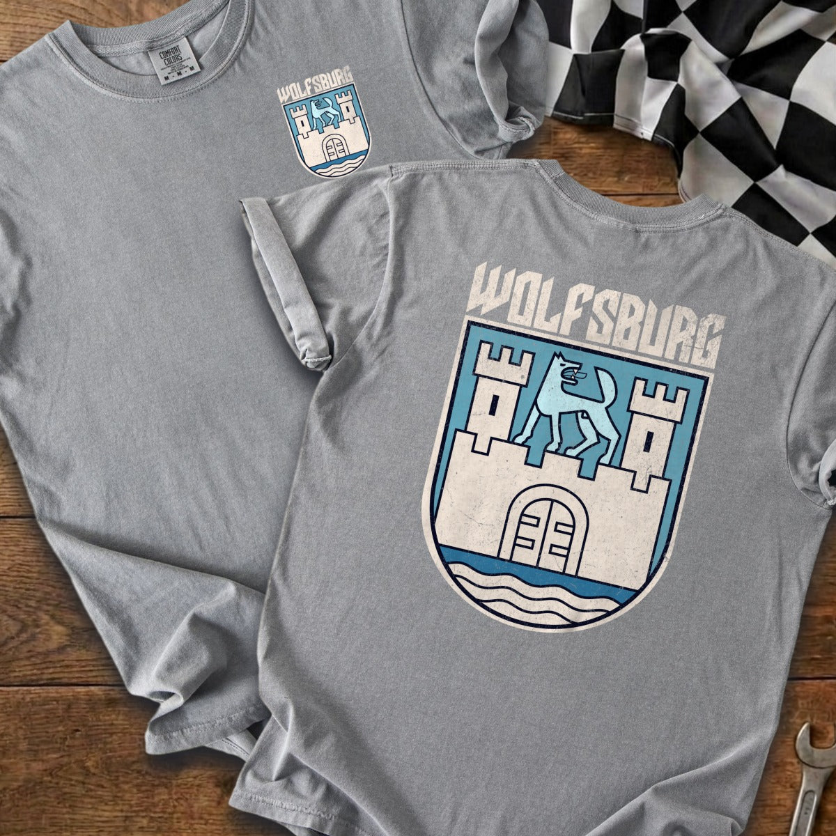Grey t-shirts featuring the Wolfsburg crest with a wolf above a castle.