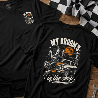 Black t-shirt with a witch on a car graphic and text "My Broom's in the Shop".