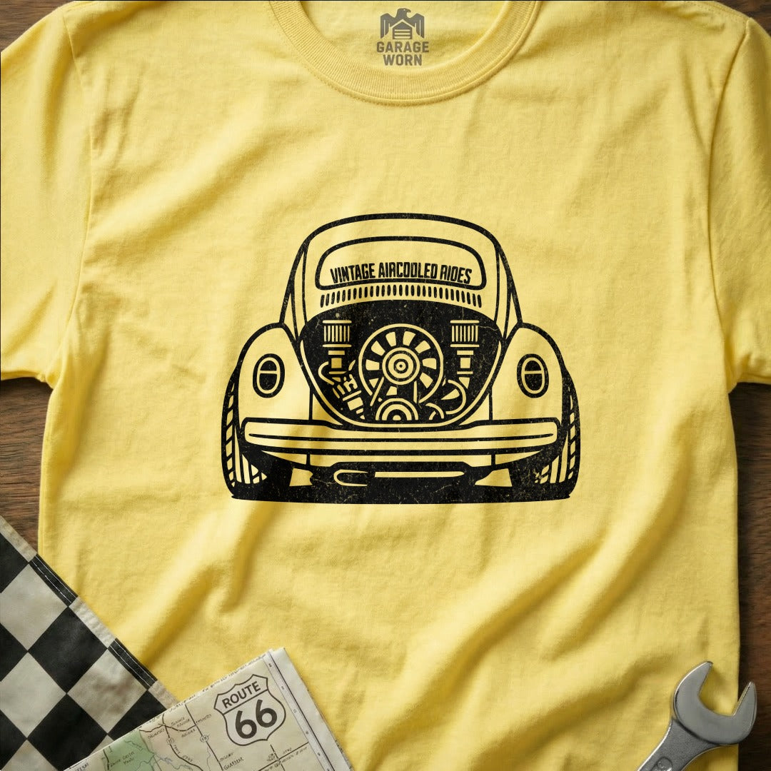 Yellow t-shirt featuring a black graphic of a vintage VW Beetle's rear engine.