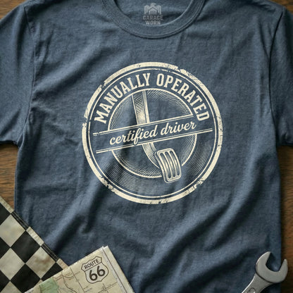 Navy t-shirt with "Manually Operated Certified Driver" emblem and clutch pedal graphic.