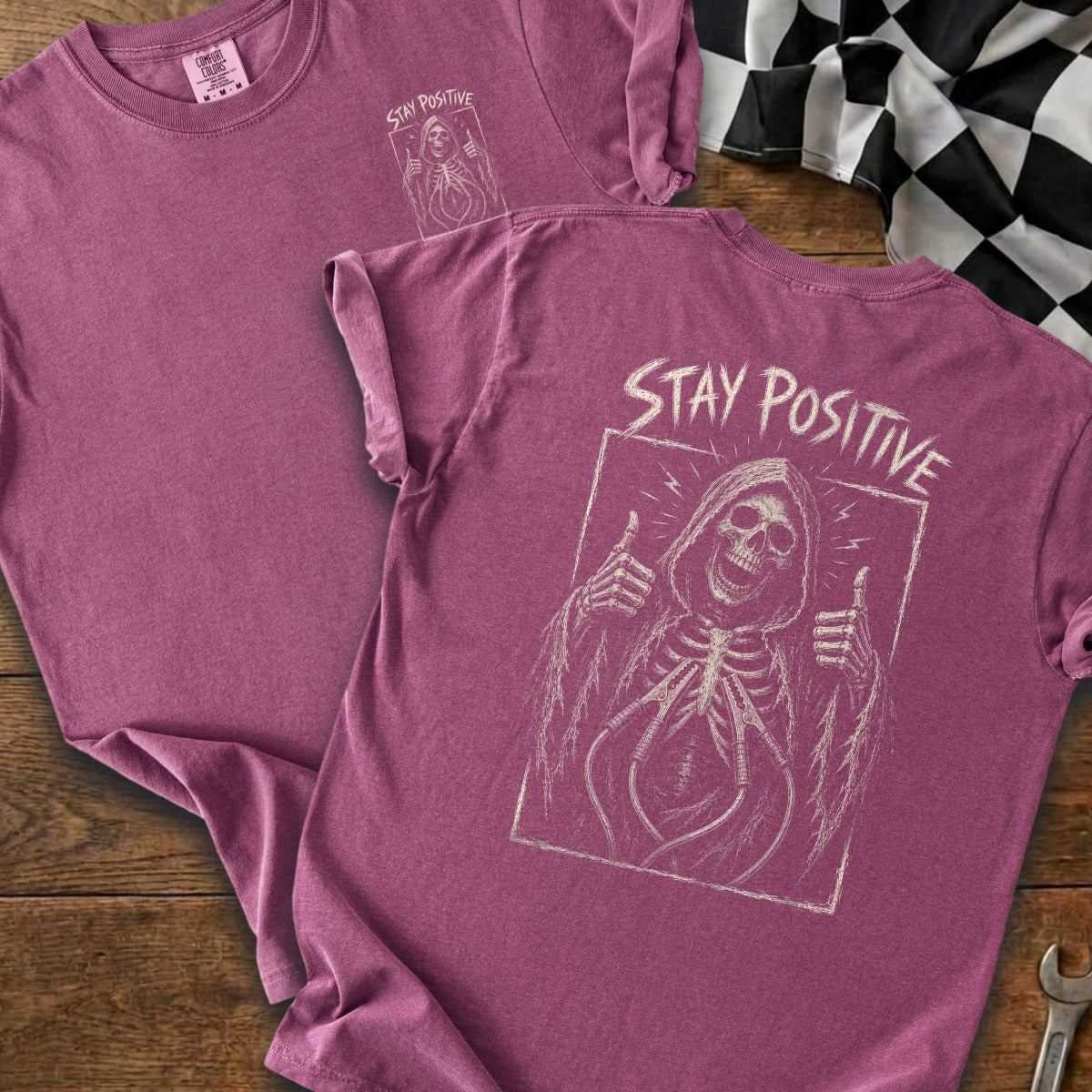 T-shirt with grim reaper skeleton giving thumbs up and "STAY POSITIVE" text.