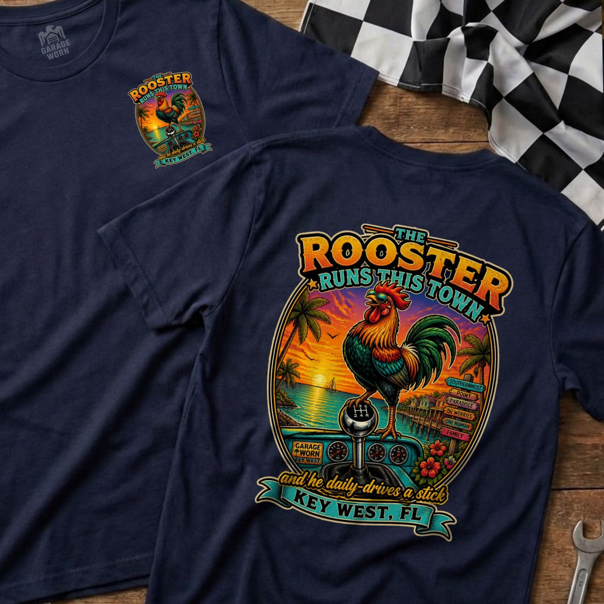 Navy t-shirt with graphic of rooster, beach sunset, and gear shift with text "The Rooster Runs This Town".