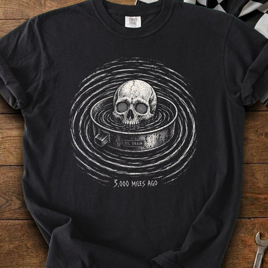 Black t-shirt featuring a skull in an oil drain with "3,000 MILES AGO" text.