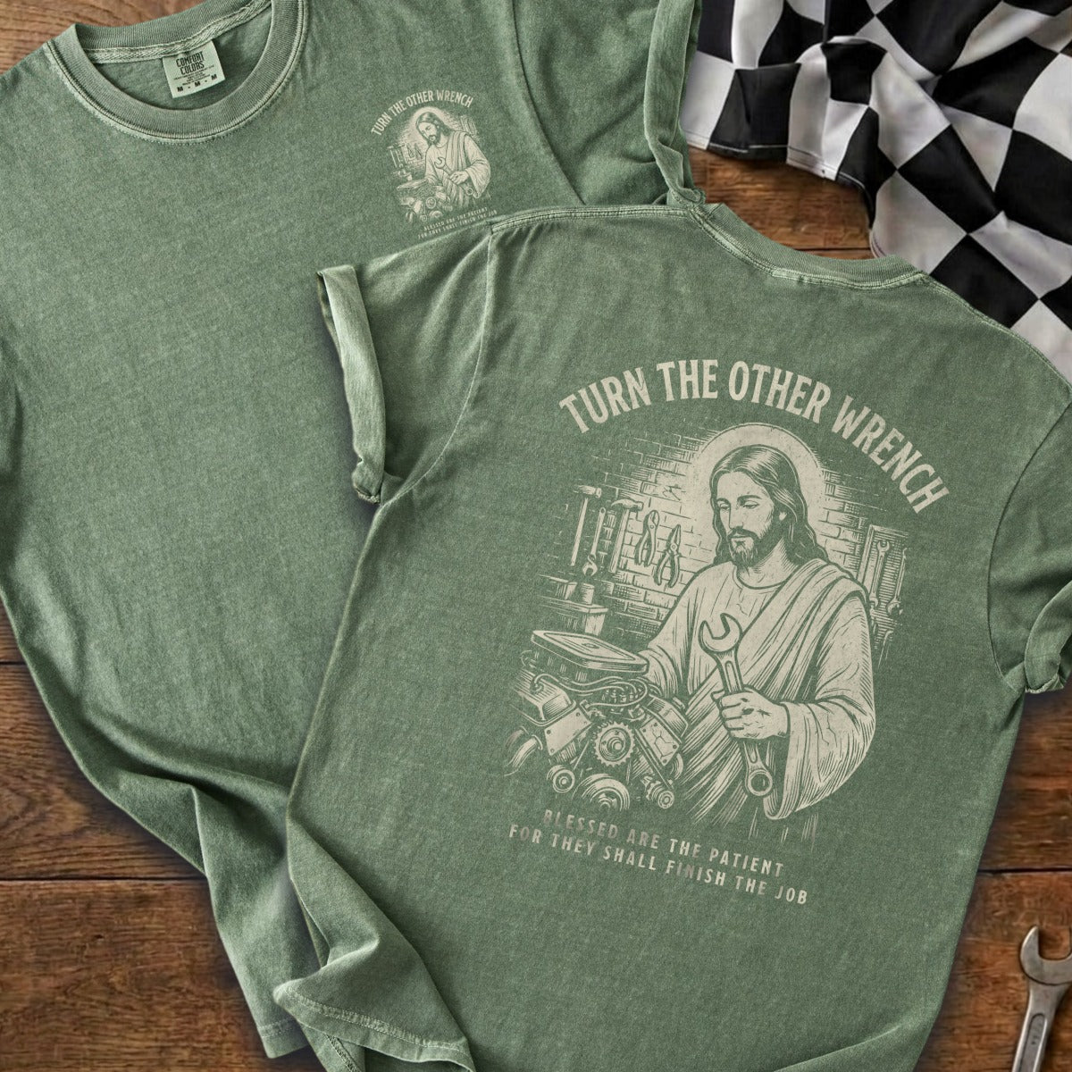 Green t-shirt with Jesus holding a wrench and engine. Text reads "Turn the other wrench".