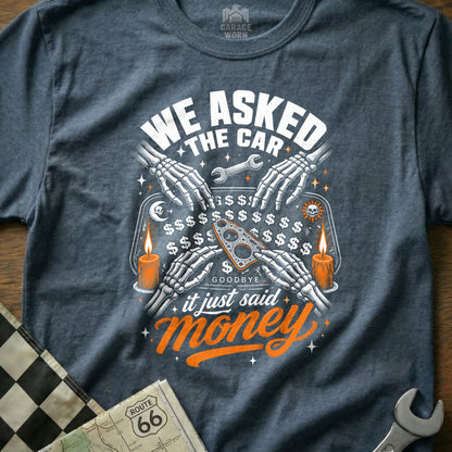 T-shirt graphic with skeleton hands, candles, and text: "WE ASKED THE CAR... it just said money."