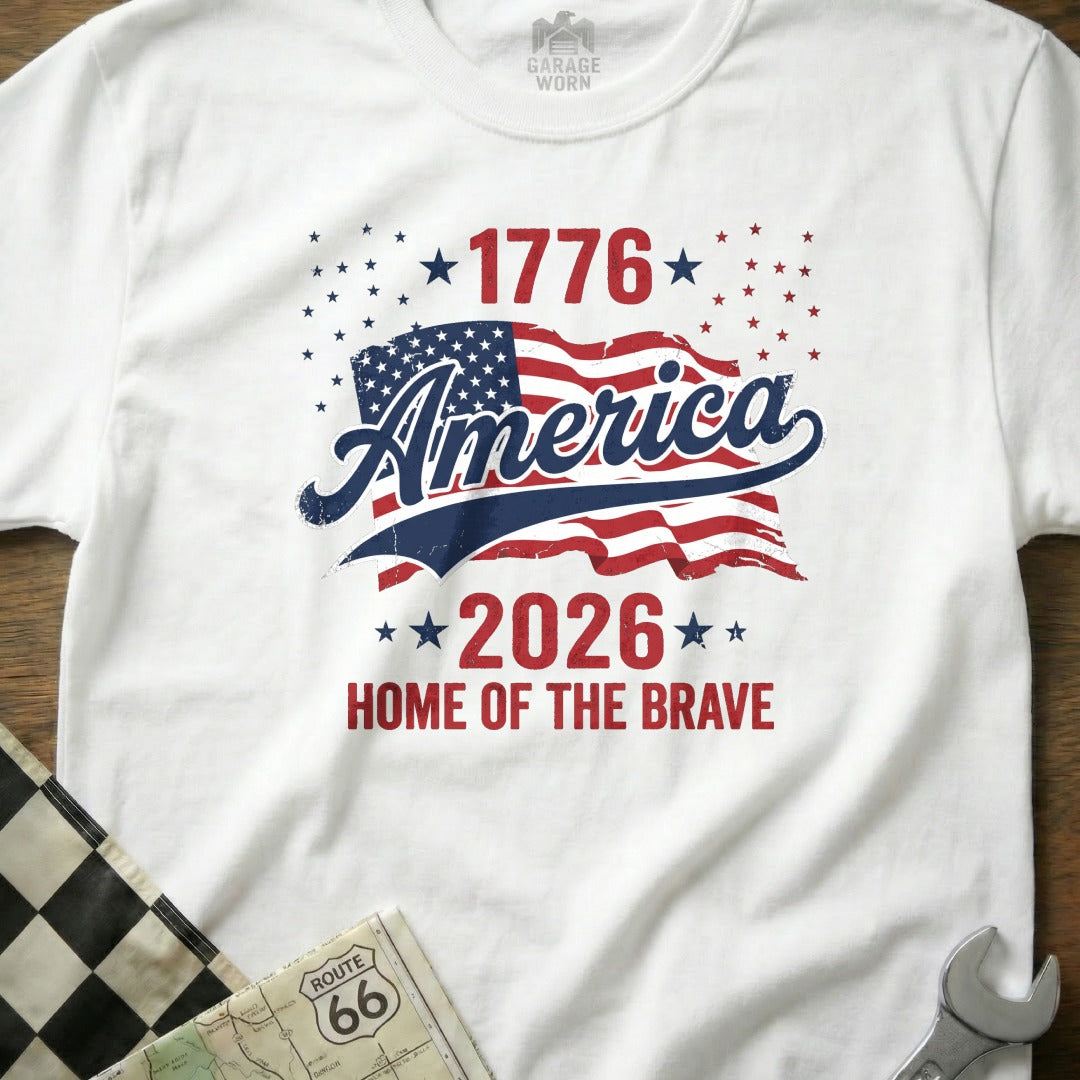 White t-shirt with "1776 America 2026 Home of the Brave" and US flag design.