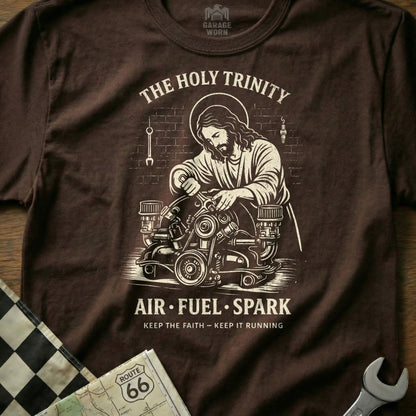 Jesus working on an engine, with text "The Holy Trinity, Air, Fuel, Spark."