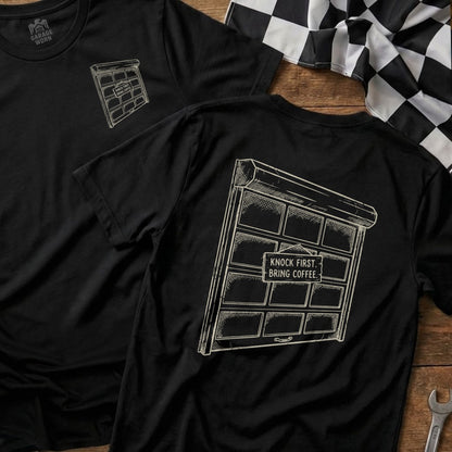 Black t-shirt with a drawing of a garage door and text "Knock first, bring coffee."