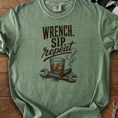 Green t-shirt graphic with text "Wrench. Sip. Repeat.," whiskey glass, cigar, and wrenches.