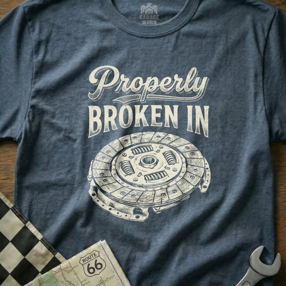 T-shirt with "Properly Broken In" text and a clutch illustration.