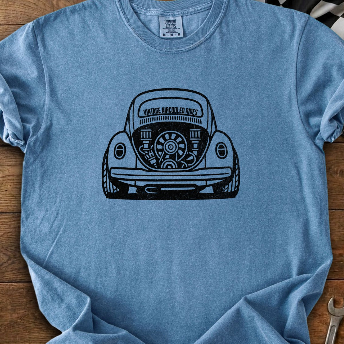 T-shirt with black graphic of air-cooled engine in the back of a vintage Volkswagen Beetle.