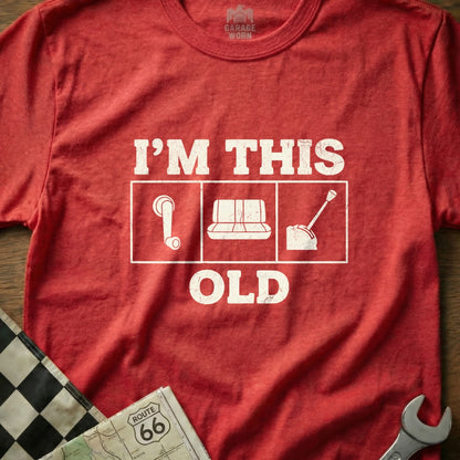 Red t-shirt with "I'M THIS OLD" and icons of a gear stick, cassette tape, and dial.