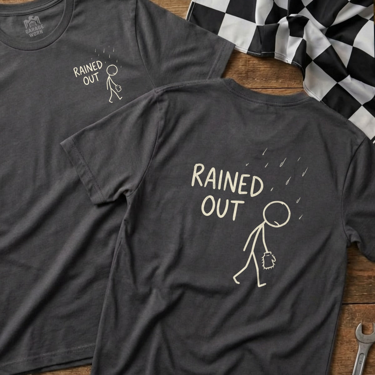 Two dark grey t-shirts with stick figure and "Rained Out" text.