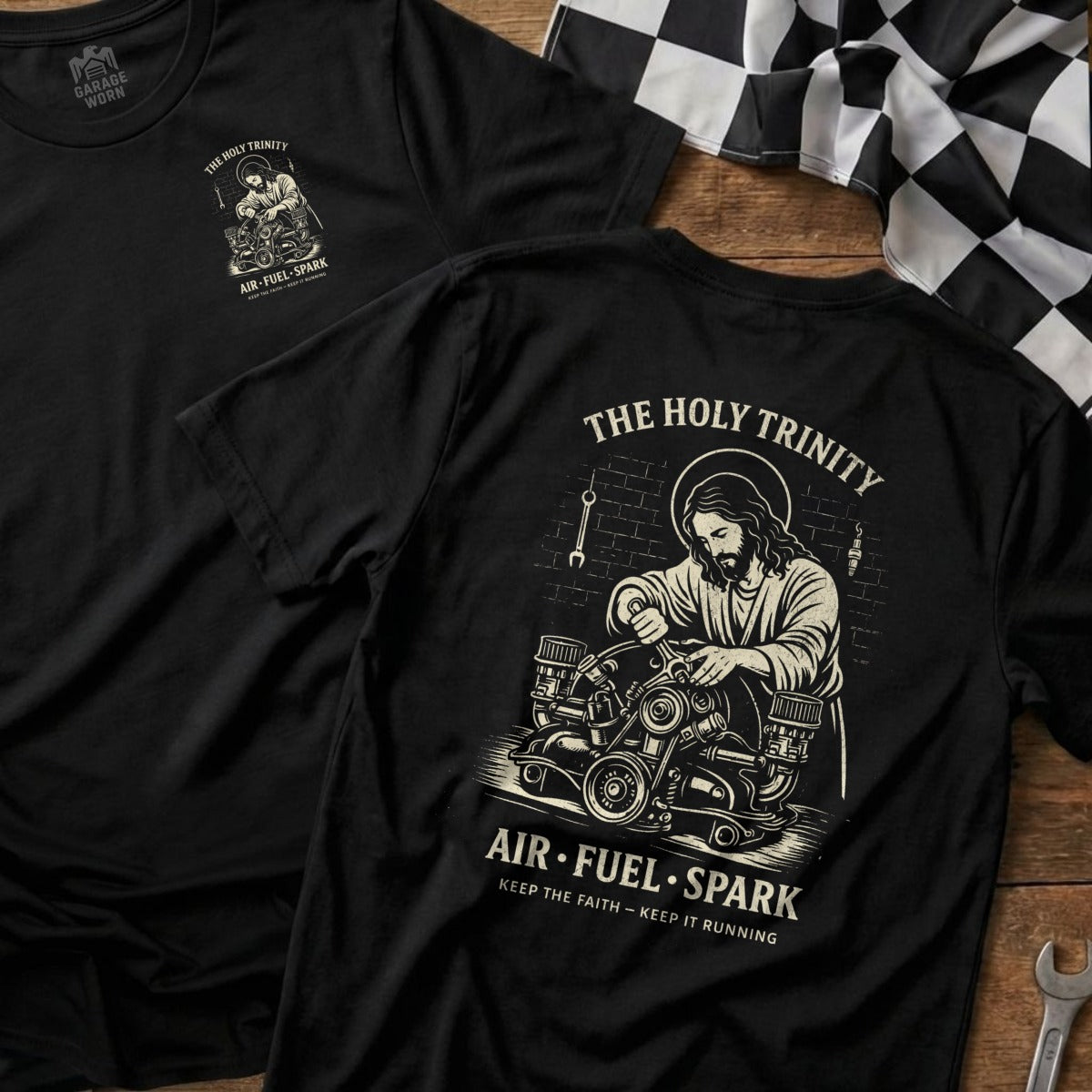 Black t-shirt with "The Holy Trinity AIR-FUEL-SPARK" graphic and Jesus working on an engine.