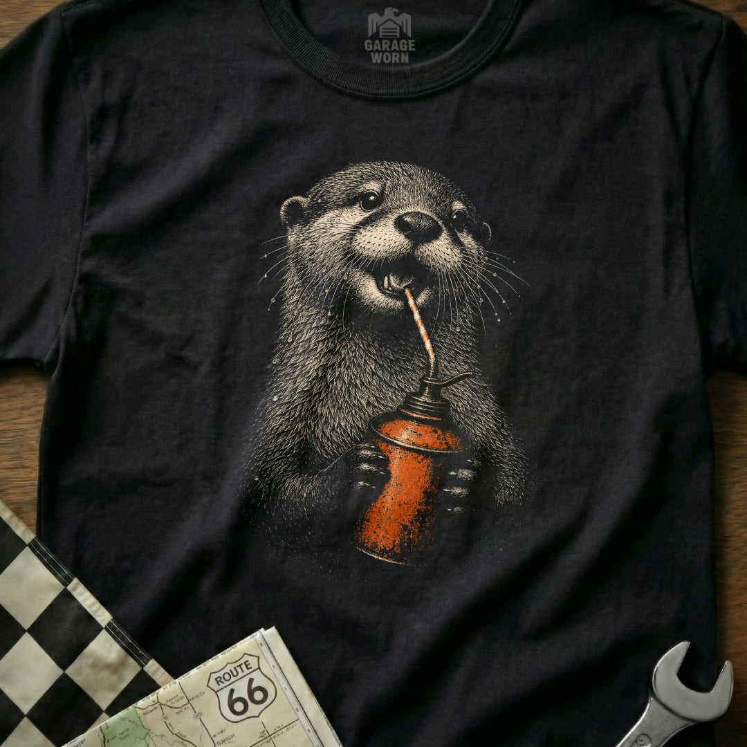 Black t-shirt with a drawing of an otter holding an oil can and drinking from it.