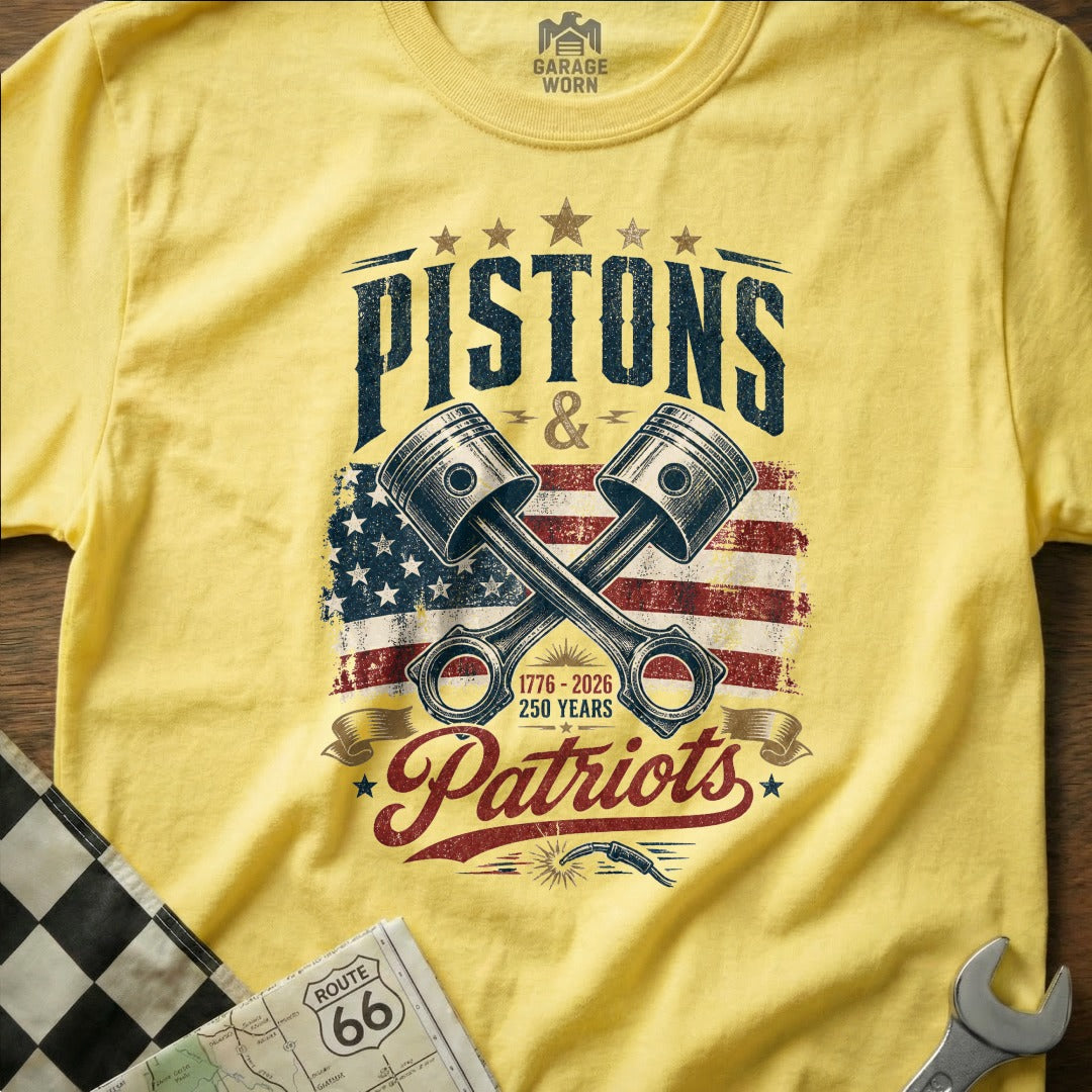 Yellow t-shirt with "Pistons & Patriots" graphic and crossed pistons over American flag.