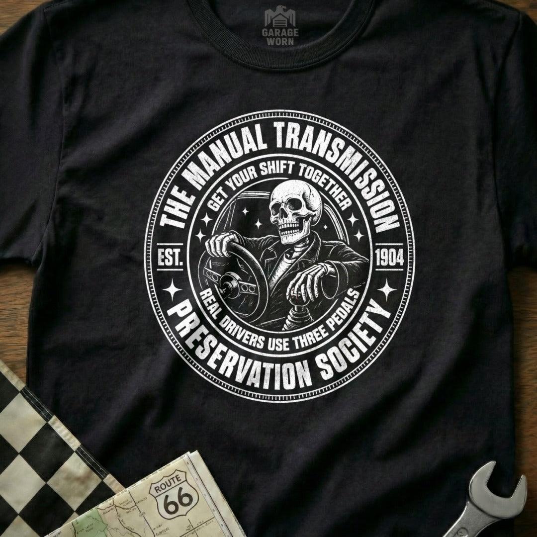 Black t-shirt with circular graphic: "The Manual Transmission Preservation Society" with skeleton driver.