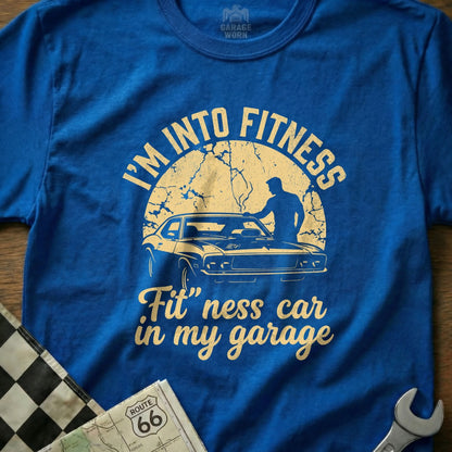 Blue t-shirt with "I'm into fitness. Fit" ness car in my garage" text and car graphic.