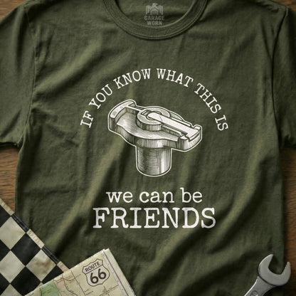 Green t-shirt with a distributor cap graphic and "we can be FRIENDS" text.