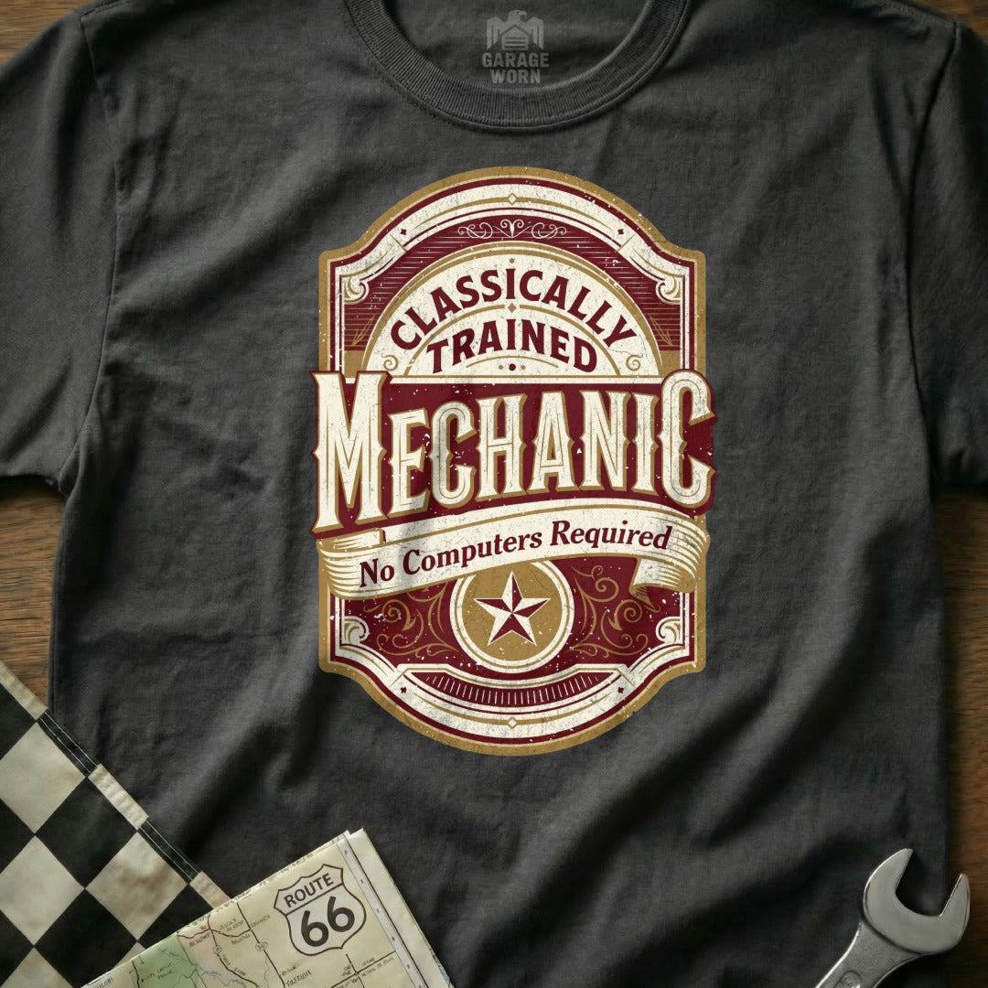 "Classically Trained Mechanic No Computers Required" emblem on a dark t-shirt.