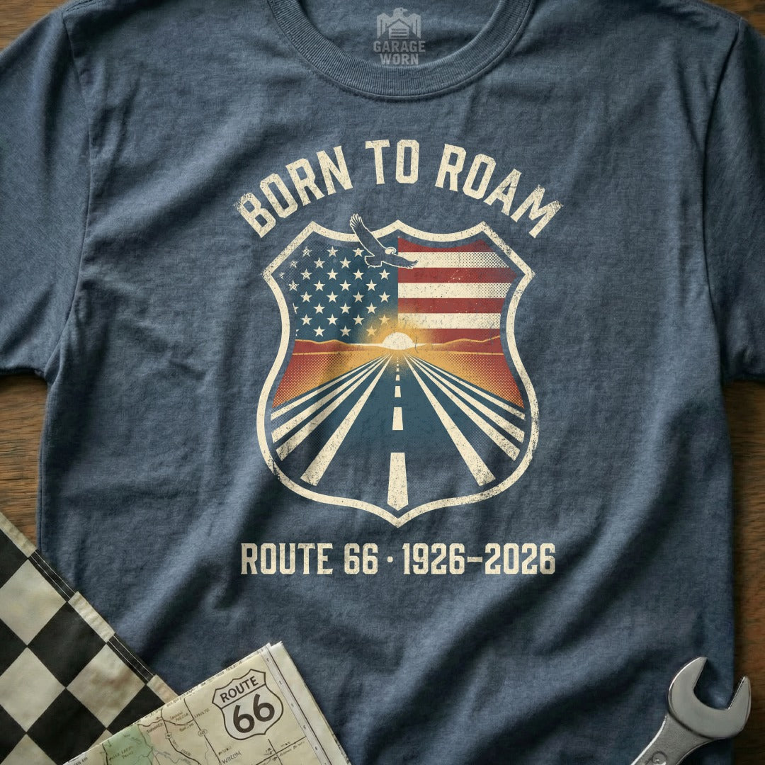 Born to Roam Route 66 1926-2026 shield graphic on a heather blue t-shirt.