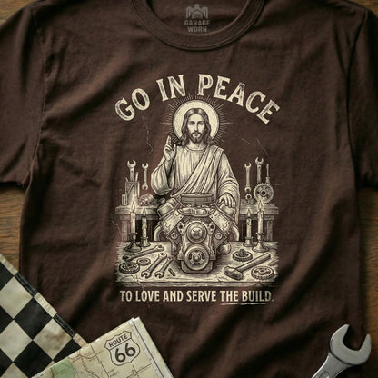 Jesus with an engine, surrounded by tools, text reads "Go in peace, to love and serve the build."