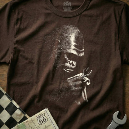 Brown t-shirt with a line drawing of a gorilla holding a wrench.